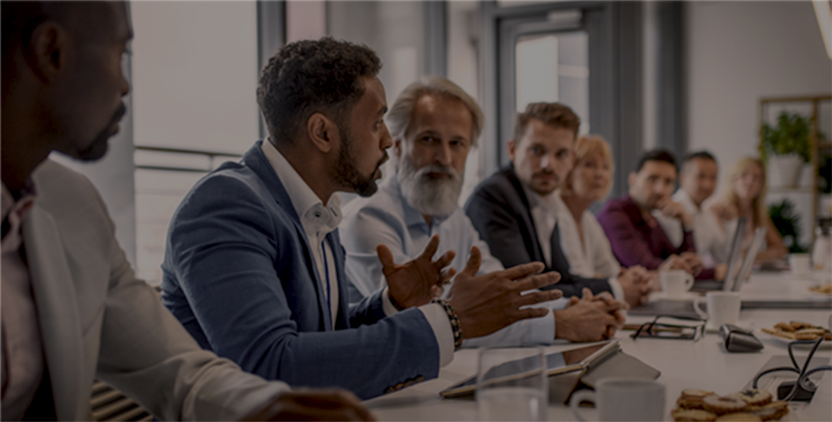 An image of business people sitting at a table having a meeting